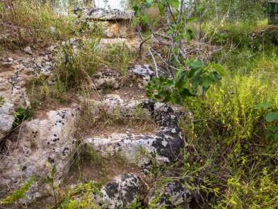 Una scaletta in pietra ci permette di scendere per cinque metri lungo la parete rocciosa...